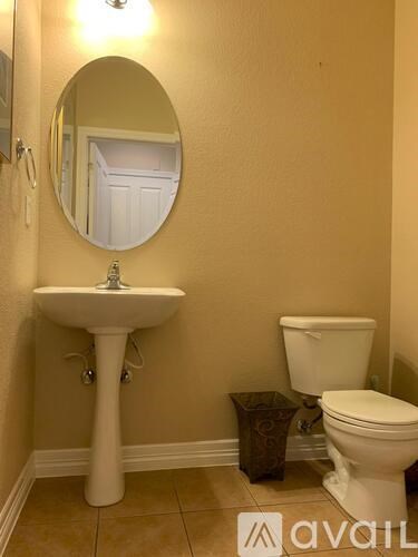 A bathroom with a sink, toilet and mirror.