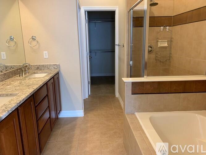 A bathroom with a tub, sink, and shower.