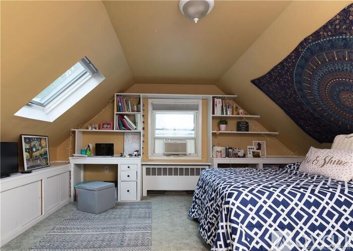A bedroom with a bed, desk, and bookshelf.