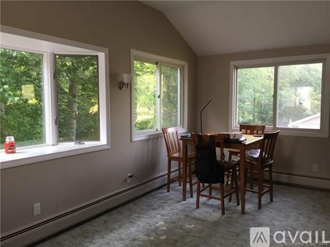 A dining room with a table and chairs.