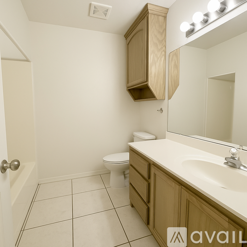 A bathroom with a toilet, sink, and mirror.