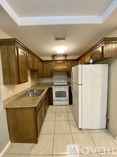 A kitchen with wooden cabinets and a white refrigerator.