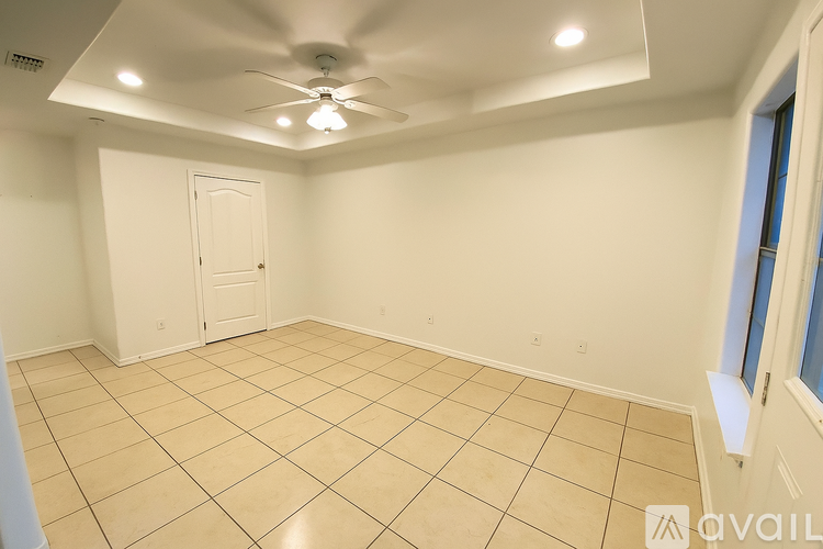 A room with a ceiling fan and tiled floor.