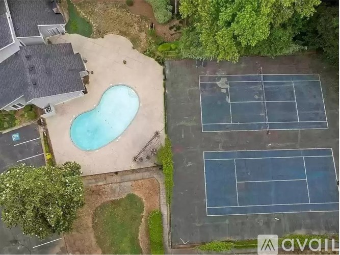 A tennis court is located next to a swimming pool.