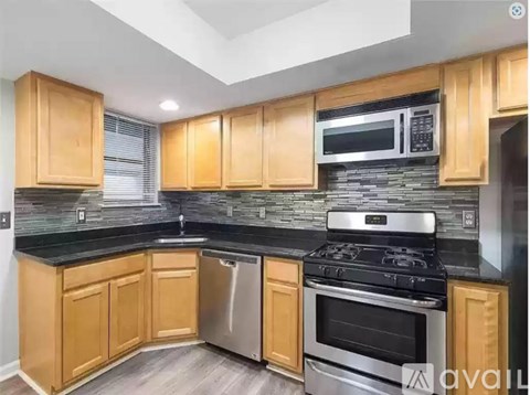 A kitchen with wooden cabinets and a black countertop.