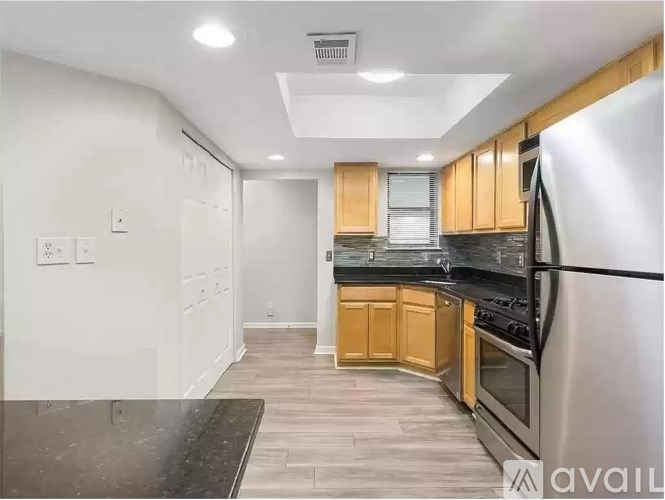 A kitchen with wooden cabinets and a black countertop.