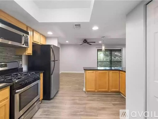 A kitchen with a black refrigerator, stove, and oven.