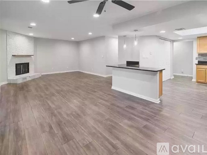 A spacious living room with a fireplace and a bar area.