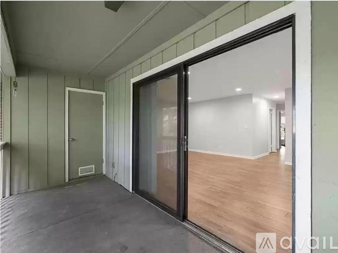 A room with a sliding door and a wooden floor.