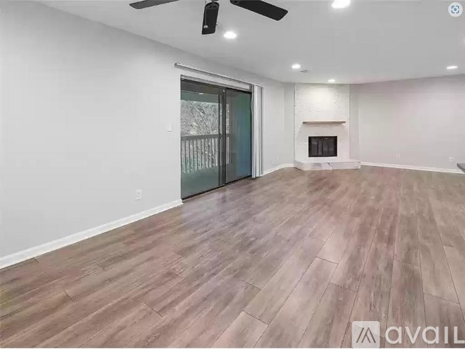 A room with a fireplace and wood flooring.