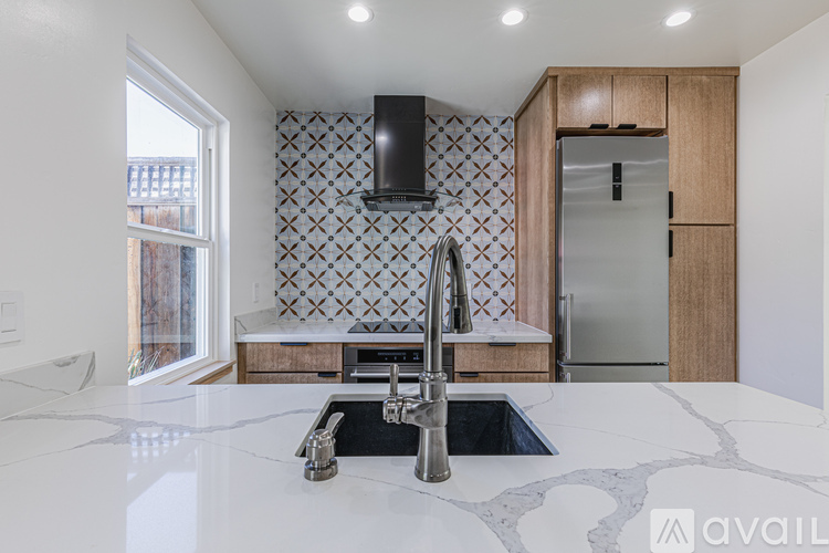 A kitchen with a marble countertop and a sink.