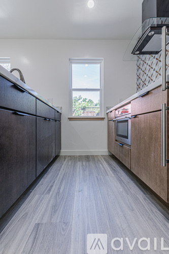 A kitchen with dark wood cabinets and a window.