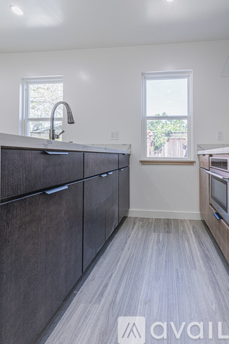 A kitchen with dark wood cabinets and a window.