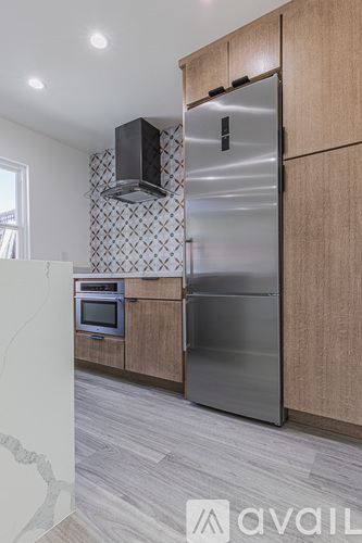 A kitchen with a refrigerator, oven, and microwave.