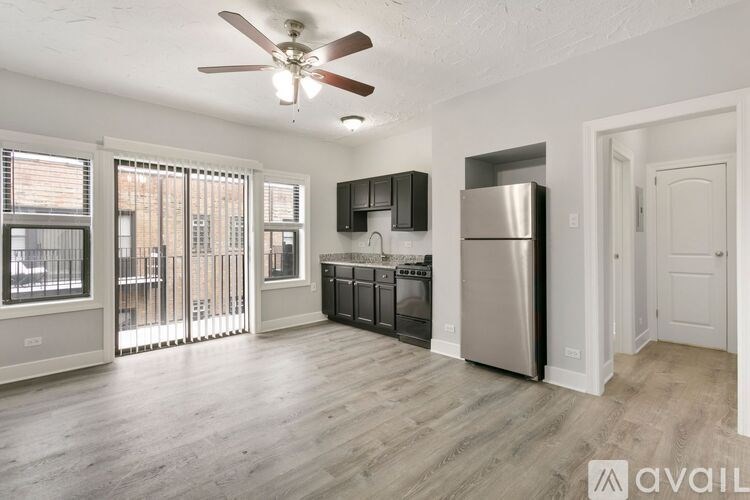 A modern kitchen with stainless steel appliances and a ceiling fan.