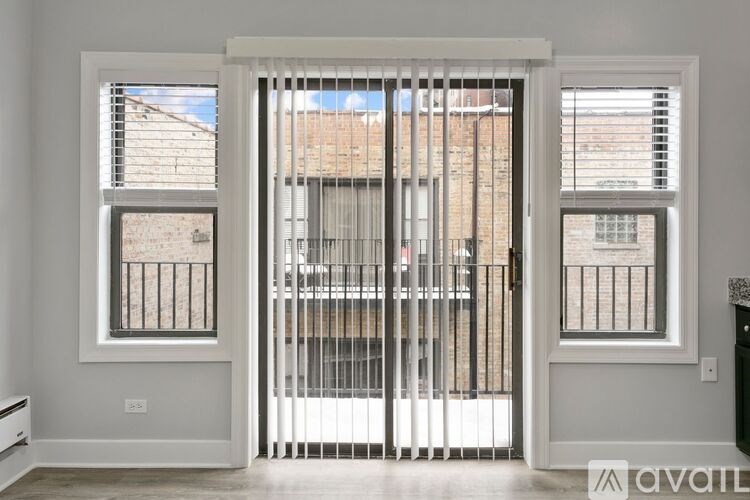 A white door with a metal gate is open, leading to a balcony with a railing.