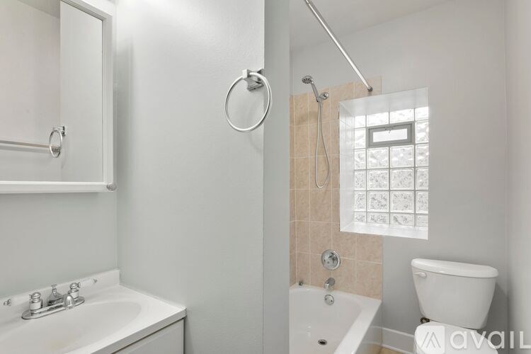 A white bathroom with a toilet, sink, and shower.