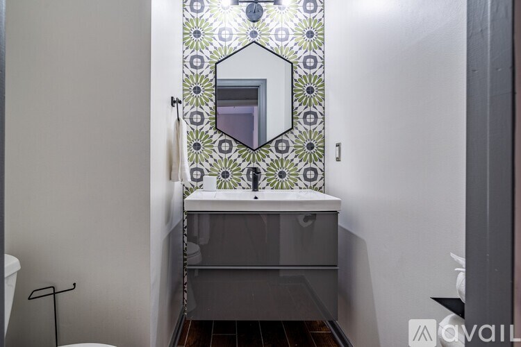 A bathroom with a mirror and a sink.
