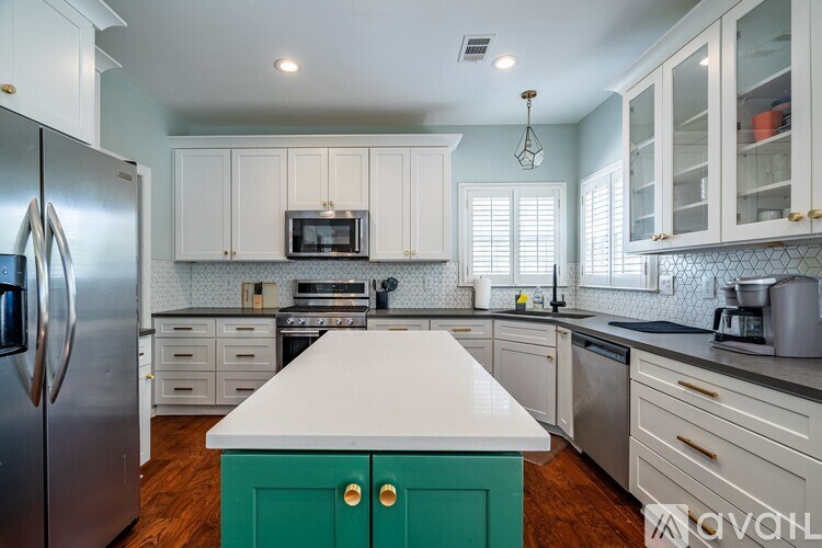 A kitchen with a white counter top and green cabinet doors.