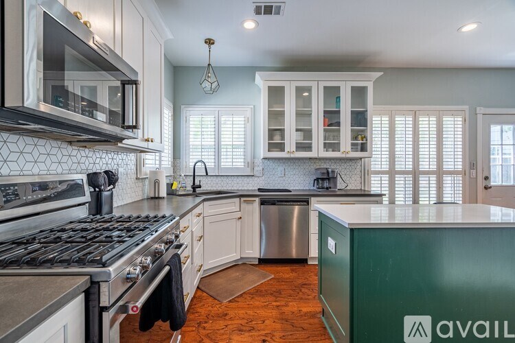 A kitchen with a green cabinet and a stove top oven.