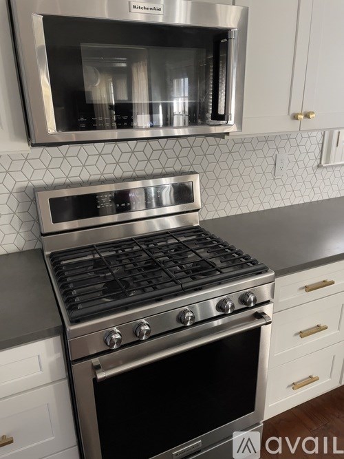 A modern kitchen with a stainless steel oven and microwave above it.