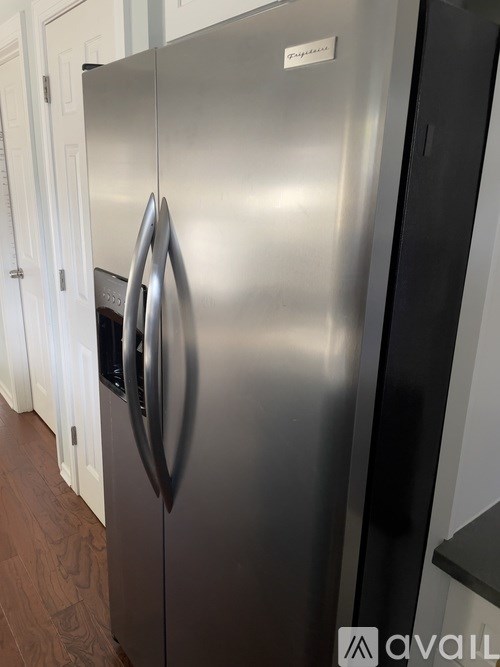 A stainless steel refrigerator with a black door on the right side.