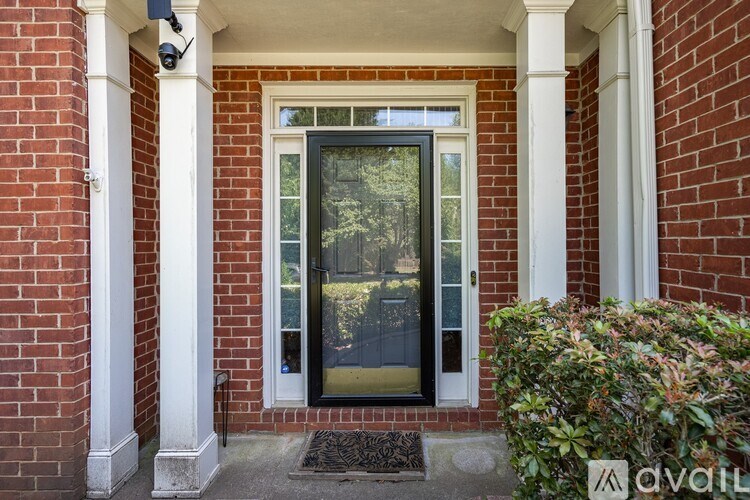 A black door is set in a white framed opening between two white columns.