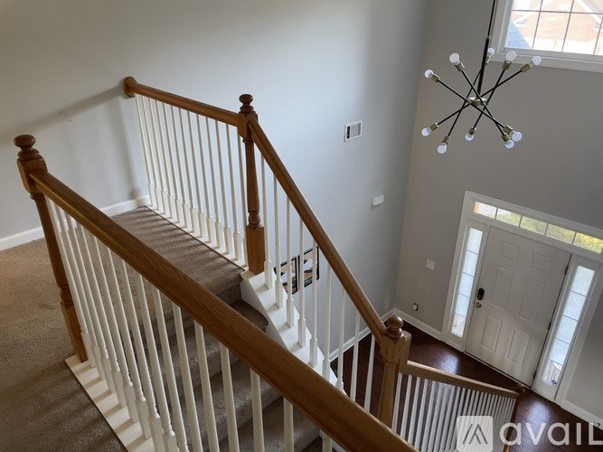 A staircase with a wooden handrail and a carpeted runner.