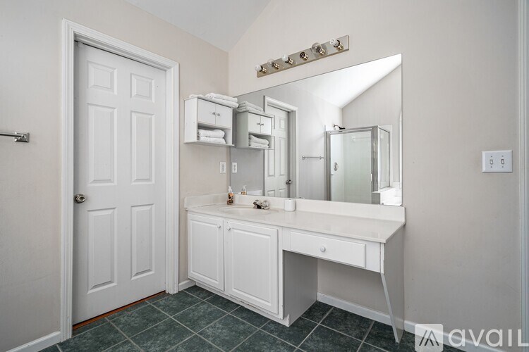 A bathroom with a white vanity and a white door.