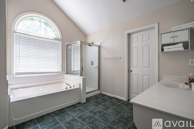 A bathroom with a bathtub, sink, and window.