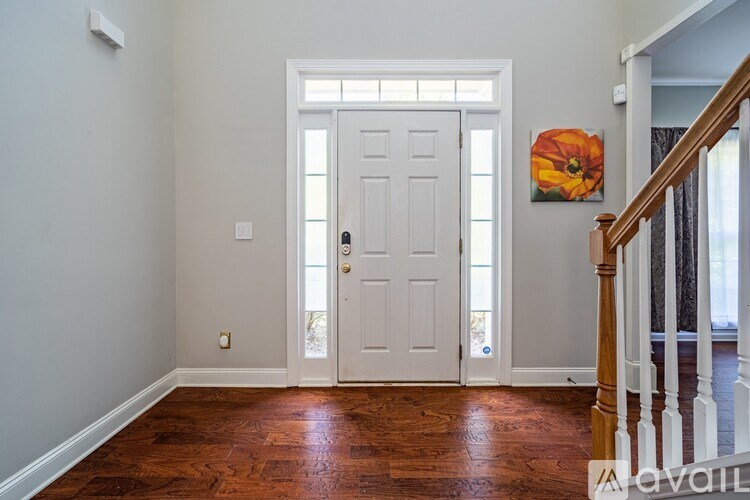 A room with a white door and a wooden floor.
