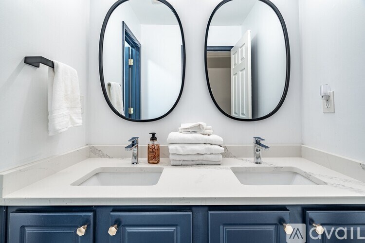 A bathroom with two sinks and two round mirrors.