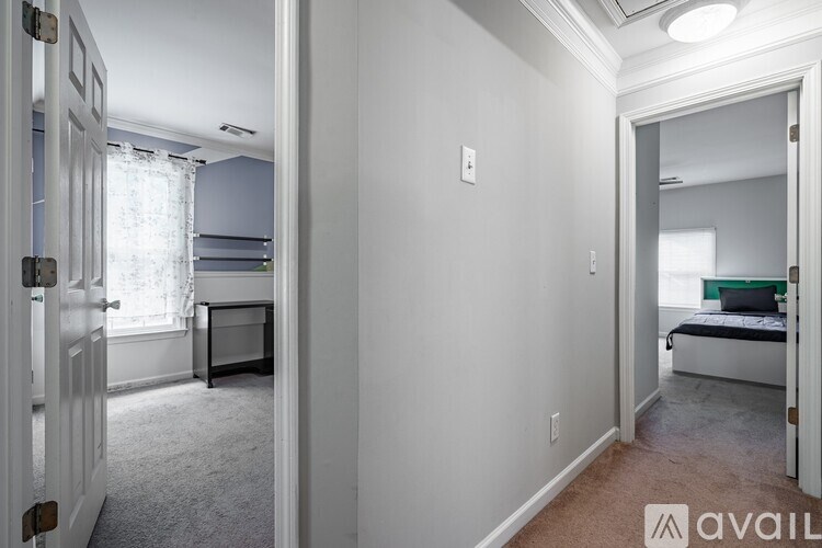 A bedroom with a bed, desk, and window.