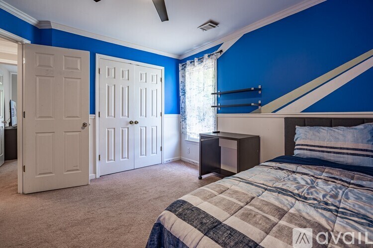 A bedroom with blue walls and a bed in the foreground.
