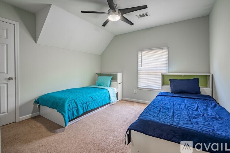 A bedroom with two beds and a ceiling fan.