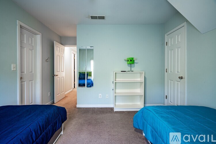 A bedroom with two beds and a dresser.