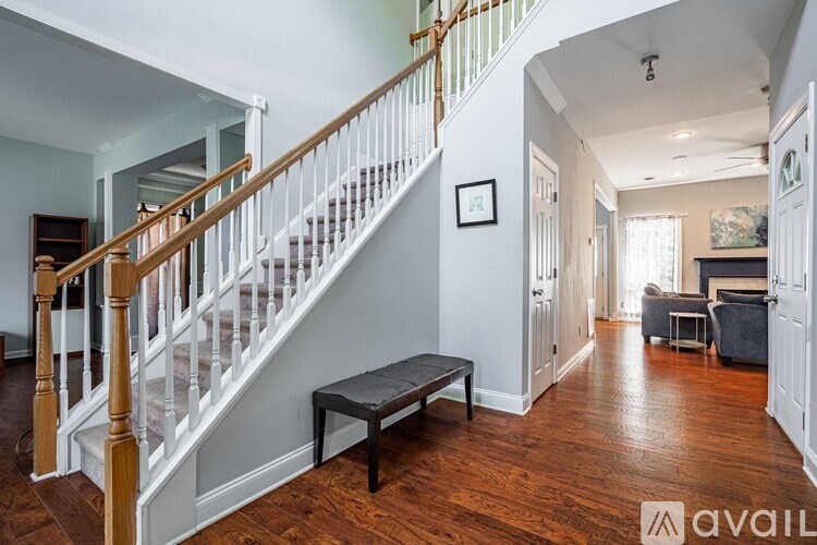 A wooden staircase with white railings leads to a second floor.