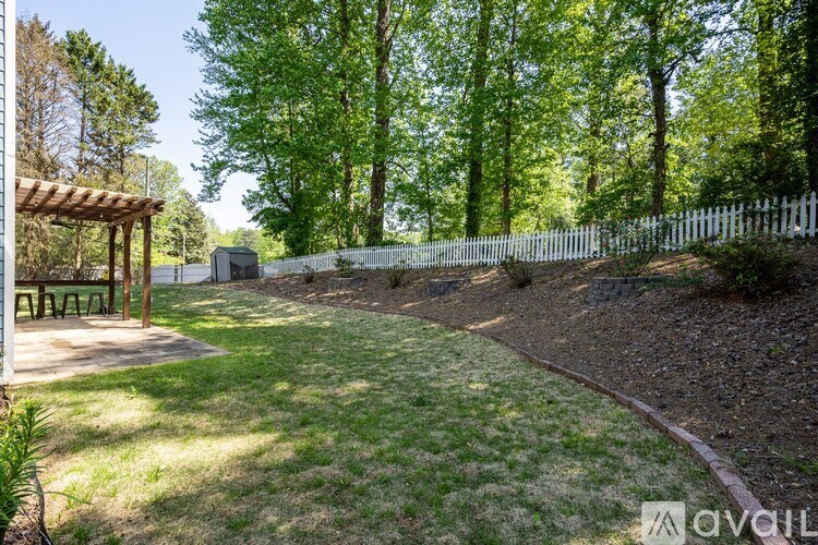 A backyard with a picnic table and a fence.