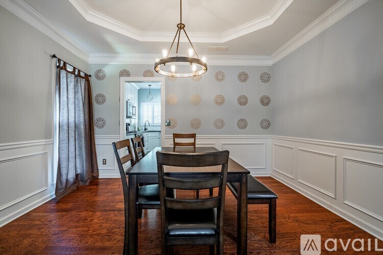 A dining room with a wooden table and chairs.