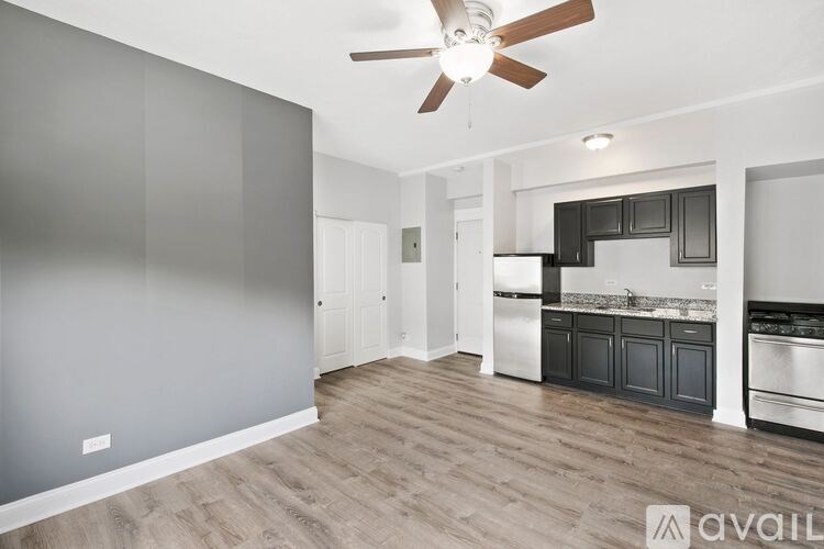 A spacious kitchen with a ceiling fan and wooden flooring.