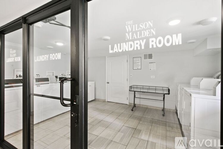 A laundry room with a sign that says "The Wilson Malden Laundry Room".
