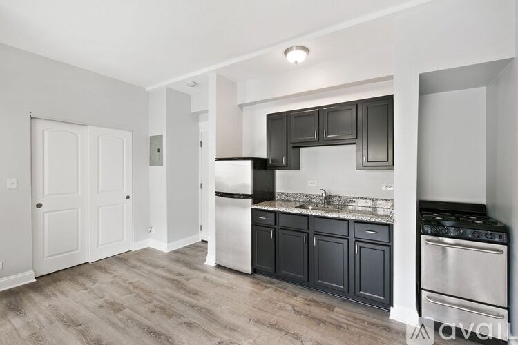 A kitchen with black cabinets and stainless steel appliances.