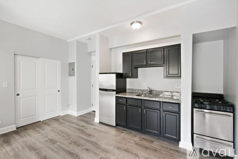 A kitchen with black cabinets and stainless steel appliances.