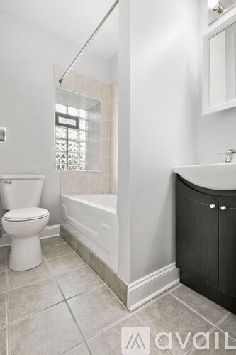A bathroom with a toilet, sink, and bathtub.