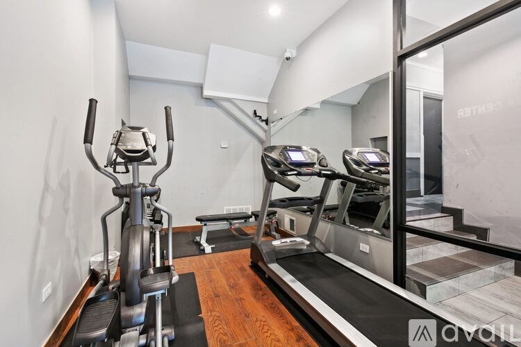 A gym with treadmills, elliptical machines, and other exercise equipment.