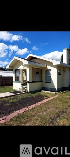 A house with a white exterior and a brown roof is shown.