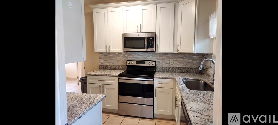 A kitchen with granite countertops and stainless steel appliances is available for rent.