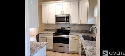 A kitchen with granite countertops and stainless steel appliances is available for rent.