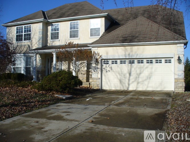 A large house with a white garage door is for sale.