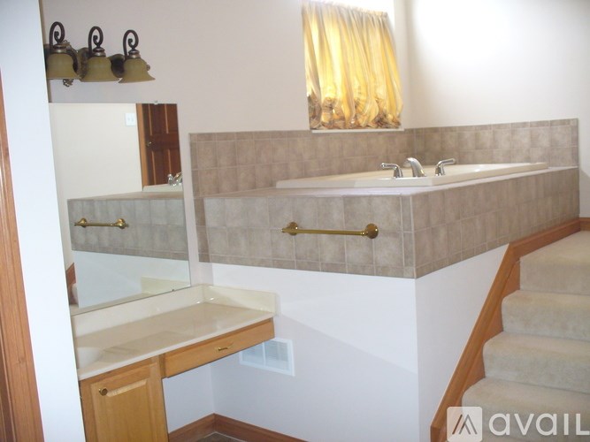 A bathroom with a sink, mirror, and stairs.